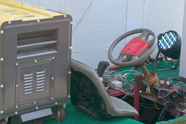 Keltainen bensiini generaattori vanhan ja ruosteen auton
 - Valokuva, kuva
