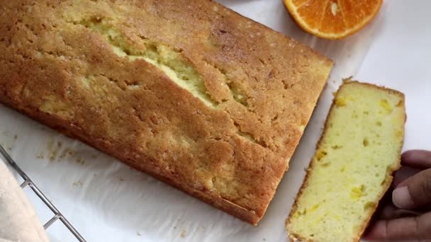 Slicing the loaf of Orange pound cake, also known as citrus loaf cake or orange butter cake. Moist, flavorful dessert, with zesty glaze perfect for food lovers, baking enthusiasts, for sweet cravings - Footage, Video