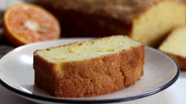 Sinaasappelglas gegoten op de plakjes sinaasappelcake, ook bekend als citrusbroodcake of sinaasappelbotercake. Vochtig, smaakvol dessert, met pittige glazuur perfect voor liefhebbers van eten - Video