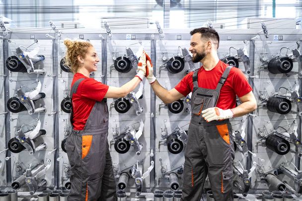 Factory workers high five by production line.  - Foto, Bild