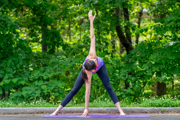 En medio del bullicio del campus, una estudiante universitaria morena serena encuentra tranquilidad a través del yoga, haciendo una pausa con gracia de las clases para un descanso rejuvenecedor - Foto, imagen