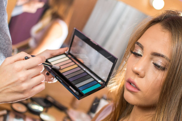 Žena make-up umělec výběru správné oční stíny pro mladé ženy zákazníka v salonu krásy. - Fotografie, Obrázek