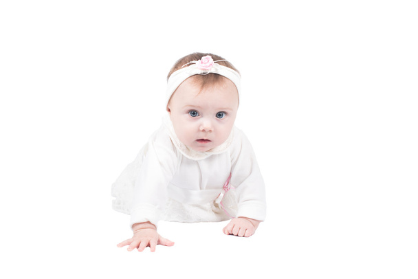 Seitenansicht der hübschen Baby-Mädchen kriechen auf dem Boden auf isolierten Studio auf weißem Hintergrund - Foto, Bild