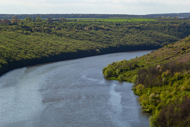 Brede rivier in groene oevers begroeid met bossen. - Foto, afbeelding