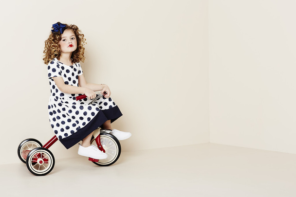 Girl on red tricycle - Zdjęcie, obraz