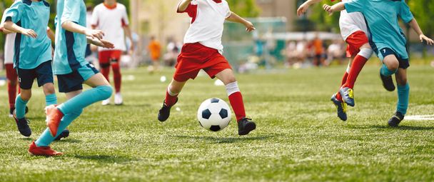 Jugadores jóvenes en el juego de fútbol. Boy Kicking Soccer Ball Towards Goal (en inglés). School Boys Playing a Soccer Football Match. Niños pateando la pelota durante la Junior Soccer League - Foto, Imagen