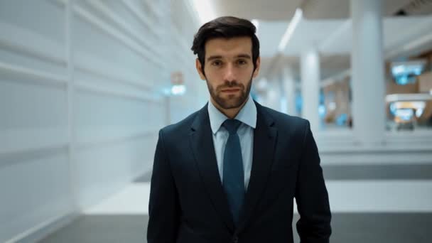 Smiling business man looking at camera while standing at mall with white background. Closeup of successful man smiling at camera while wearing business suit. Happy manager look at camera. Exultant. - Footage, Video