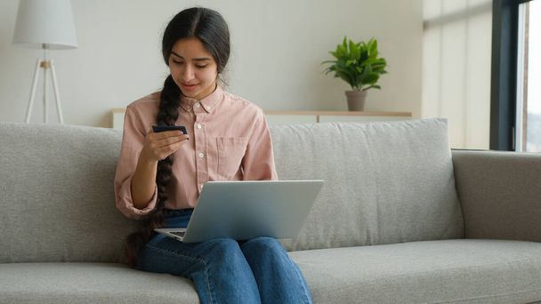 Nő ügyfél vásárlás online bankkártyával vásárolni áruk laptop biztonságos pénzügyi internetes fizetés e-kereskedelem üzlet boldog arab lány fizet digitális pénzt a honlapon megrendelés szállítás otthon - Fotó, kép