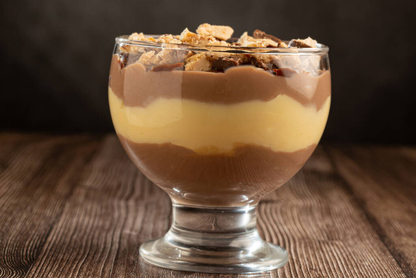 Dessert im Glas. Gebäck-Sahne-Dessert mit Schokoladen-Ganache. - Foto, Bild