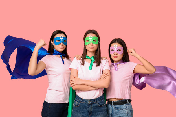 Women in superhero costumes on pink background. Women's history month - Фото, зображення