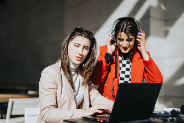 Duas empresárias profissionais trabalhando ao ar livre com laptop e fones de ouvido. - Foto, Imagem
