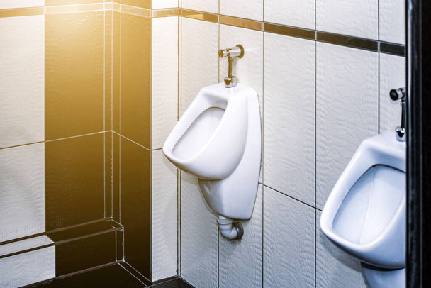 白い尿が並ぶ男性用の部屋。快適な男性用トイレの便器、モダンな清潔な公衆トイレ - 写真・画像