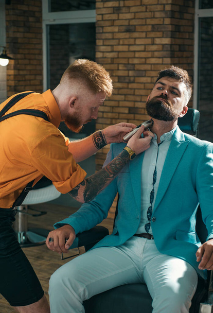 Bearded man or hipster. Ideas about Barbershop and Barber salon. Making haircut look perfect in barber shop. Fine Cuts. Professional hairstylist in barbershop interior - Foto, Bild
