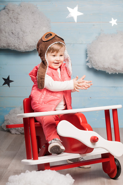 Ragazzina seduta in aereo giocattolo di legno
 - Foto, immagini