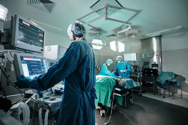 Screen, monitor or doctor in emergency surgery, professional care and hospital for support. Press, help and surgeon in operation or mask to check healthcare or track heart rate in medical results. - Photo, Image
