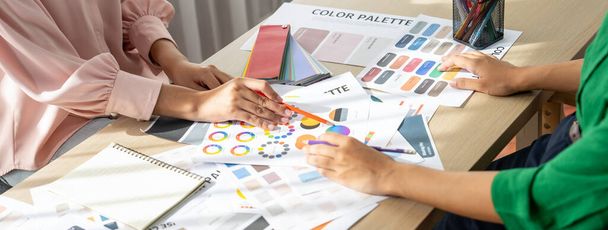 Vágott kép profi belsőépítész megvitatni és ötletbörze fő téma színe a projekt tárgyalóasztal színes paletta szétszórt körül. Kreatív belsőépítészet. Változatos. - Fotó, kép