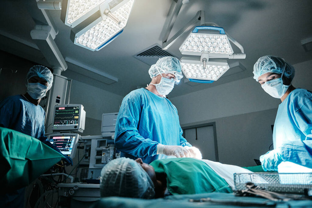 Doctor, surgeon and patient in hospital, theater and emergency room busy with operation in medical career. Healthcare, nurse and workers with staff for surgery, medicine and health in clinic. - Photo, Image