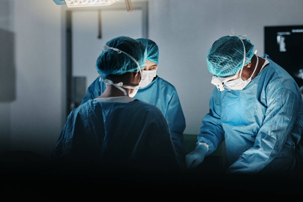 Surgeon team, people and operating room at hospital in scrubs, ppe and help for emergency healthcare procedure. Doctors, group and together in icu, medical surgery and services for wellness at clinic. - Photo, Image