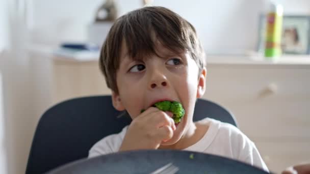 Ebédidő Fun - Fiatal fiú vesz egy nagy falat brokkoli közben tápláló vacsora - Felvétel, videó
