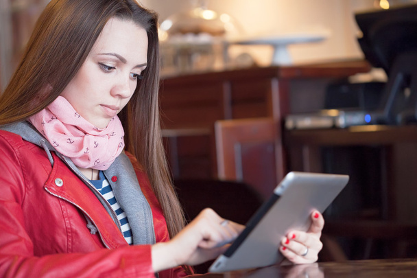 Young woman reading a digital tablet - Valokuva, kuva