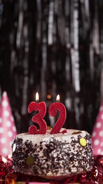 Velas ardientes número 32 en la tarta. Pastel de cumpleaños para treinta y dos años de edad. A cámara lenta. Copiar espacio. Vista vertical - Imágenes, Vídeo