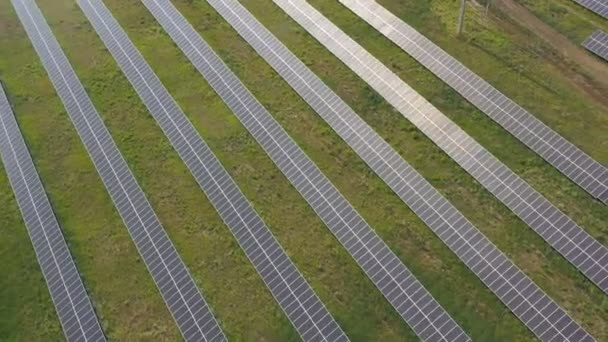 Aerial view of solar panel farm generating electricity. Rows of energy solar panels installed on farmland meadow or rural field. Concept of ecology and renewable green energy. Top shot. - Кадры, видео