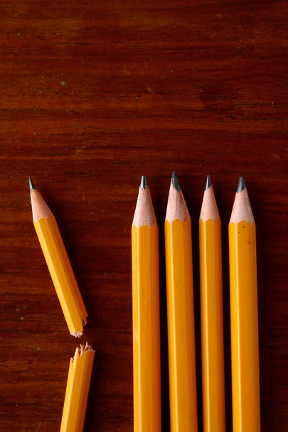 Vier goede potloden en een gebroken potlood - Foto, afbeelding