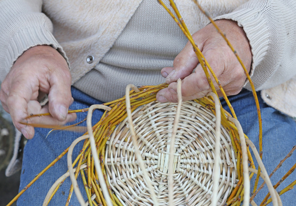 Fleißige Hände älterer Handwerker schaffen einen Weidenkorb - Foto, Bild
