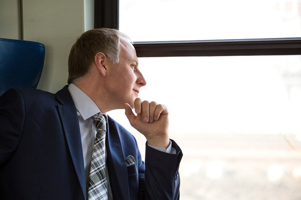 Businessman interested in what he sees through window - Photo, Image