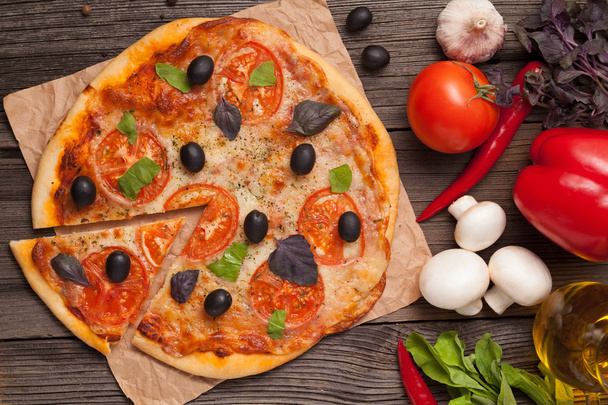 Sliced piece of italian pizza margherita with tomatoes, olives a - Фото, зображення