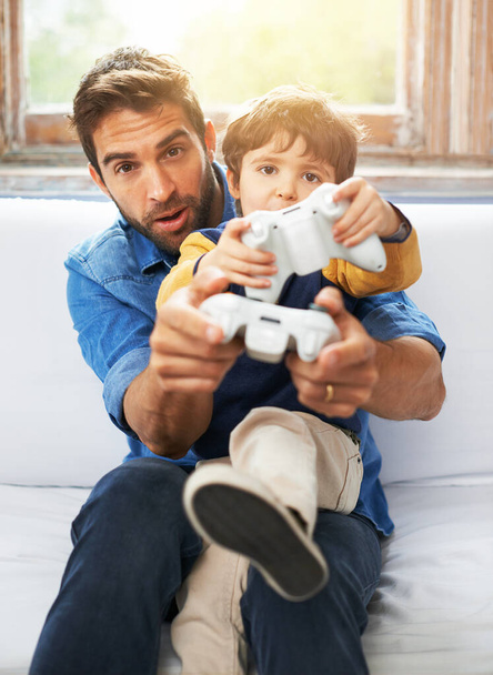 Father, kid or remote to play, gaming or virtual to relax, esports or technology in living room. Dad, child or controller on sofa to teach, fun or challenge as video game, bonding or together. - Photo, Image