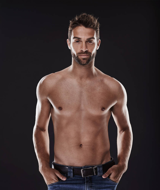 Portrait, abs and body of confident man in studio isolated on black background for wellness, fitness or exercise. Face, topless and muscle of person for health, serious or strong bodybuilder in Spain. - Photo, Image