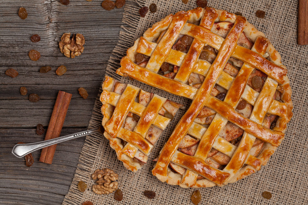 Кусок нарезанного яблочного пирога с металлической лопаткой на винтажном дереве
 - Фото, изображение