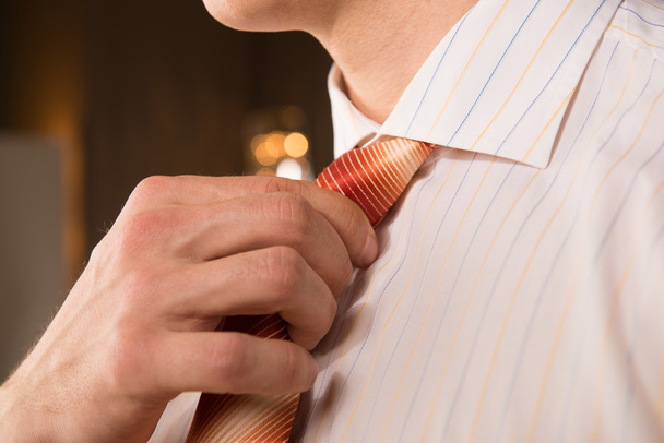 Красивый бизнес. Обрезанный образ молодого человека при настройке галстука
 - Фото, изображение