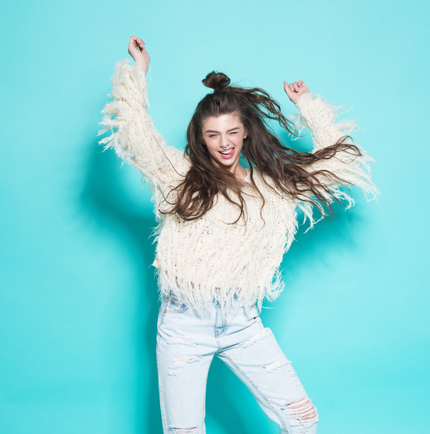 Portret van vrolijke mode hipster meisje dat gek grappig gezicht maken en dansen. Blauwe kleur achtergrond. - Foto, afbeelding