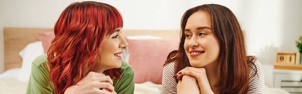 happy young lesbian couple in casual attire having cozy moment and looking at each other, banner - Foto, imagen