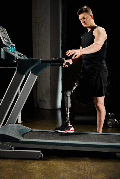 Um homem com uma perna protética fica em uma esteira rolante, enquanto exercita-se no ginásio. - Foto, Imagem