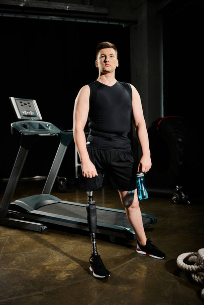 Mies, jolla on proteesi jalka seisoo juoksumatto hämärässä huoneessa, aktiivisesti mukana harjoitusrutiini. - Valokuva, kuva