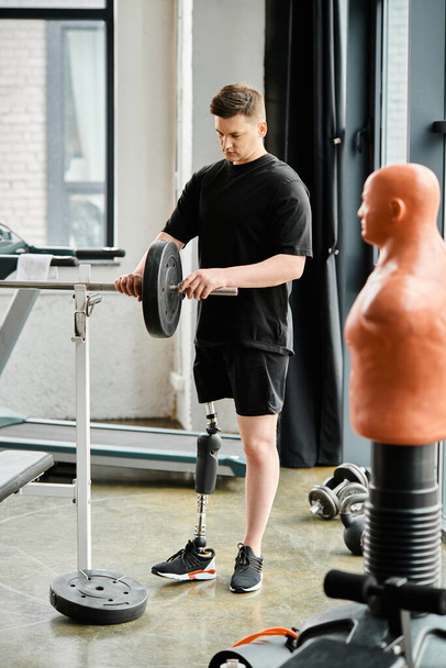 Niepełnosprawny mężczyzna z protezą nogi stoi obok sportowej maszyny w nowoczesnym pokoju. - Zdjęcie, obraz