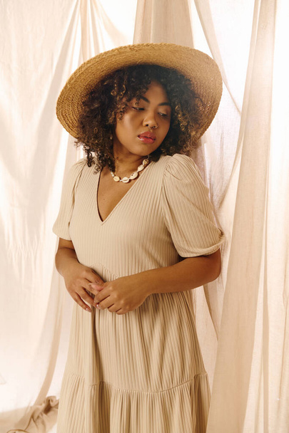Eine schöne junge Afroamerikanerin mit lockigem Haar trägt elegant ein Sommerkleid und Strohhut und strahlt Anmut und Stil aus. - Foto, Bild