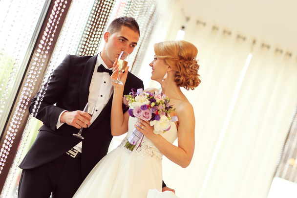 Bride and groom holding glasses of champagne - Foto, Bild