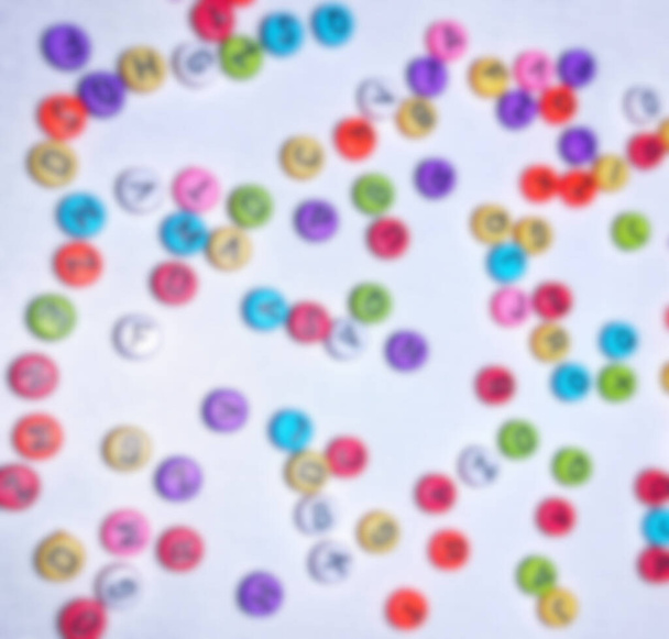 Not focus blur background photo of colorful round alphabet, colorful round numbers, round colorful letters on a white background - Photo, Image