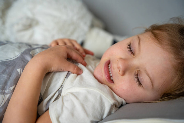 Roztomilá holčička spící a skřípající zuby ve snech, zaťaté zuby únavou a stresem. Kvalitní fotografie - Fotografie, Obrázek