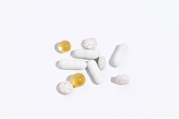 Kapseleiden, antibioottien ja pillereiden eri värit valkoisella eristetyllä taustalla. Konsertti apteekki, terveys, sairauksien hoito. Suunnittelun taustaa - Valokuva, kuva