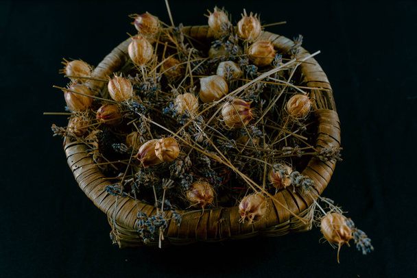 Koš z rostlinného materiálu naplněný sušenými květy různých velikostí - Fotografie, Obrázek