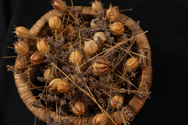 Koš z rostlinného materiálu naplněný sušenými květy různých velikostí - Fotografie, Obrázek