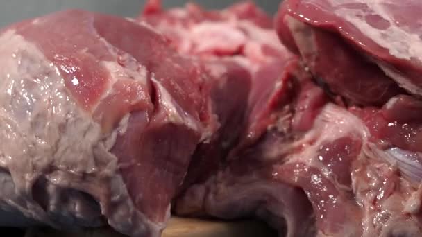 Egy fekete kesztyűs férfi disznóhúst vág a vágódeszkára. Sertésszeletelés kecsesen és precízen. - Felvétel, videó