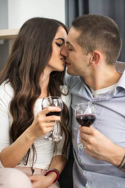 Молода пара цілується і п'є червоне вино
 - Фото, зображення