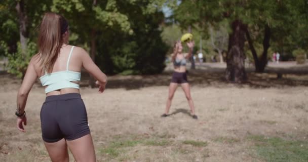 Aktivní mladé přítelkyně těší míč hry venku. Fitness, volný čas a letní zábava zachycené v živé scéně parku. - Záběry, video