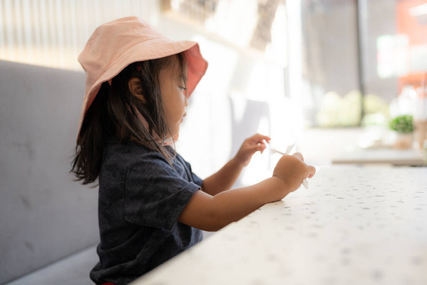 Маленькая красивая трехлетняя девочка в кафе - Фото, изображение